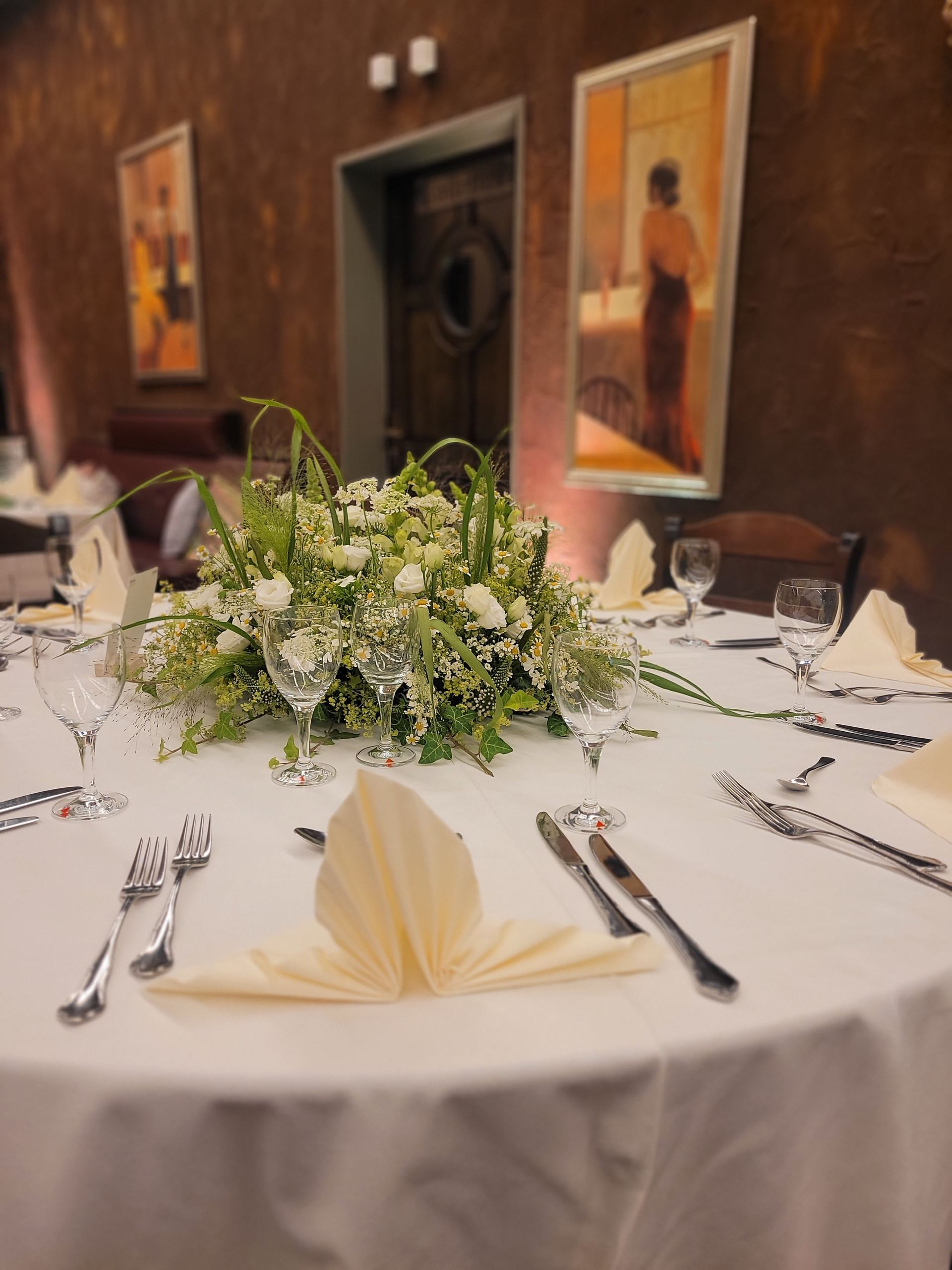 Lange Tafel mit Blumendekoration im Brauhaus