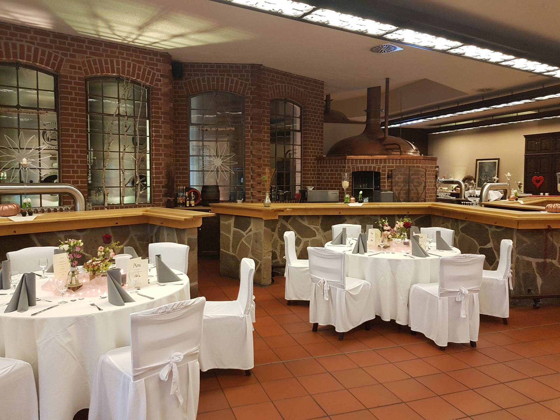 Festsaal mit Stuhlhussen und Kupferkessel im Hintergrund